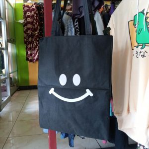 ini adalah Totebag Senyum, size: 40cm x 35cm, material: canvas, color: black, brand: totebagbjnindonesia, age_group: all ages, gender: female